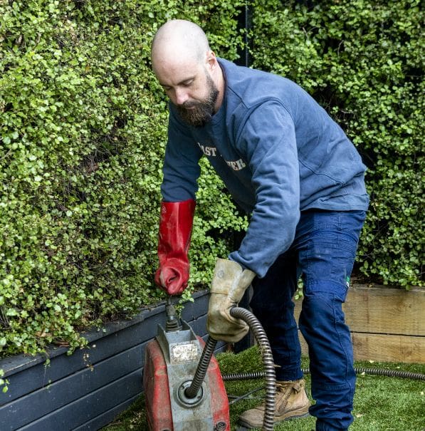 A plumber clearing a blocked drain